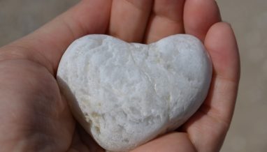 hand holding a heart shaped stone
